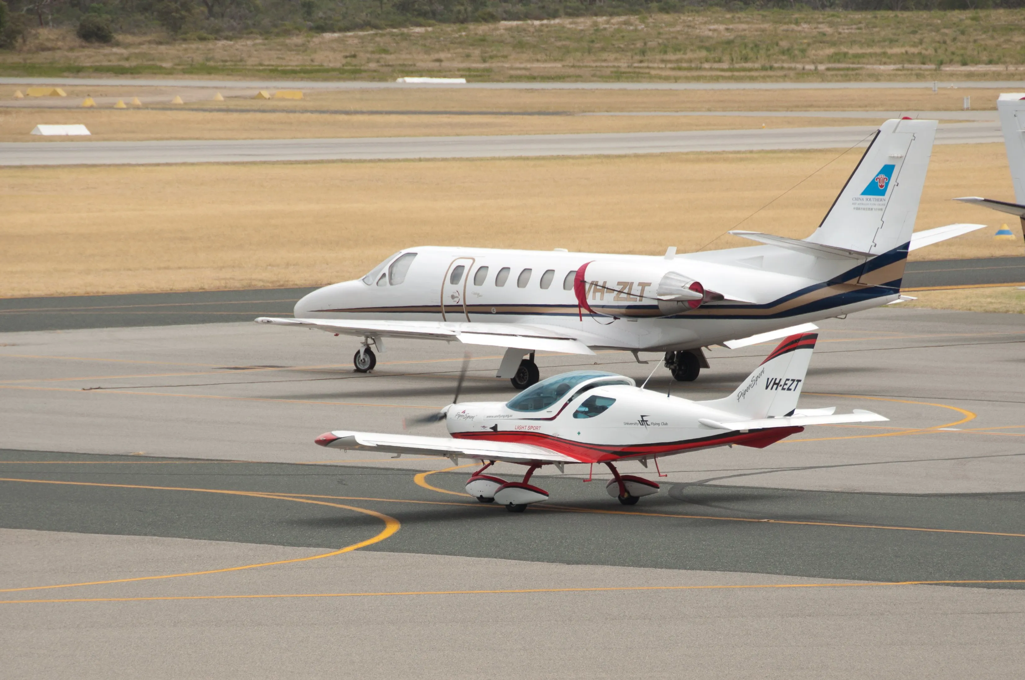VH-EZT taxiing past a Citation jet at Jandakot