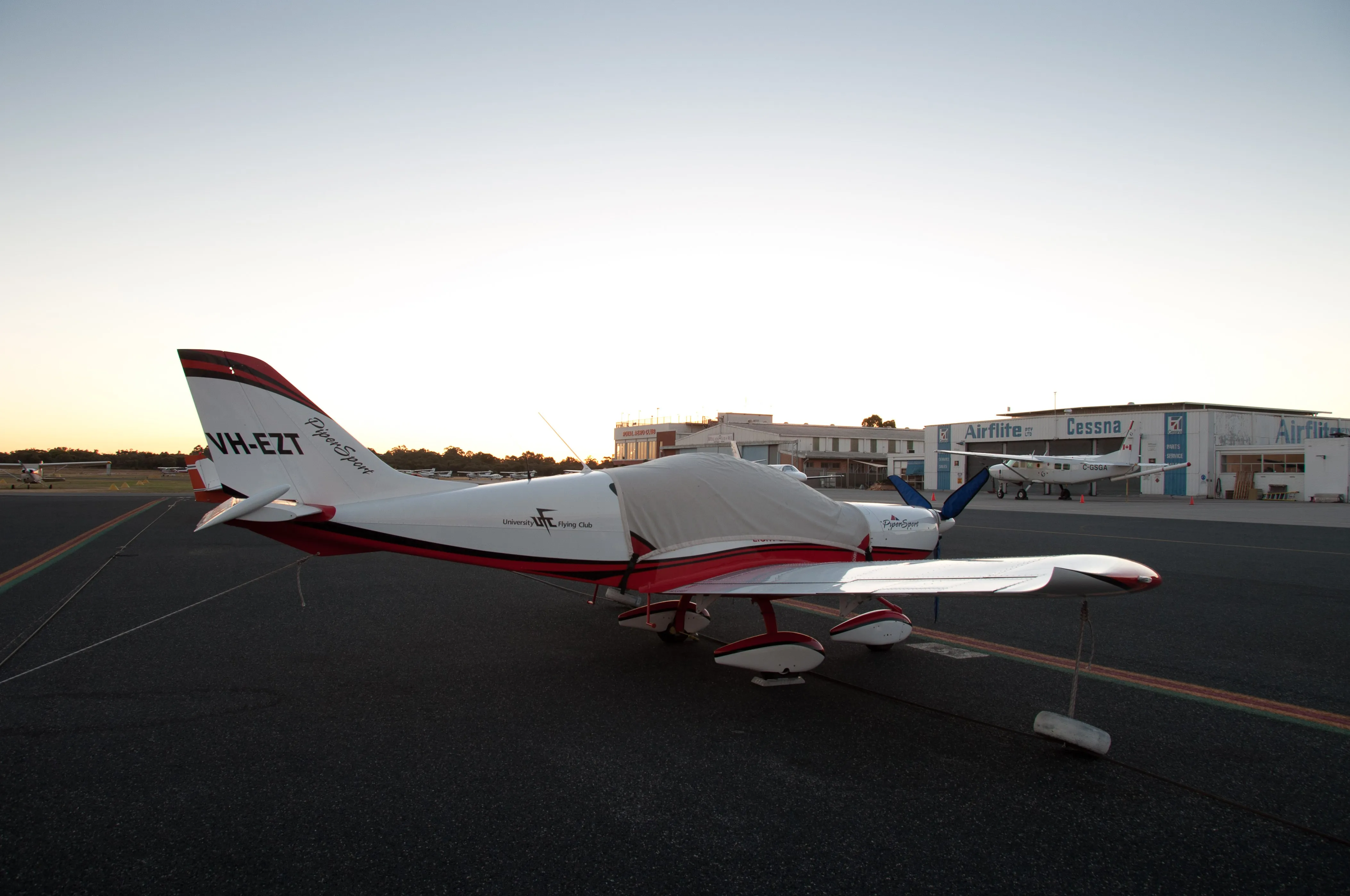 VH-EZT under its canopy cover on the apron at Jandakot at dusk