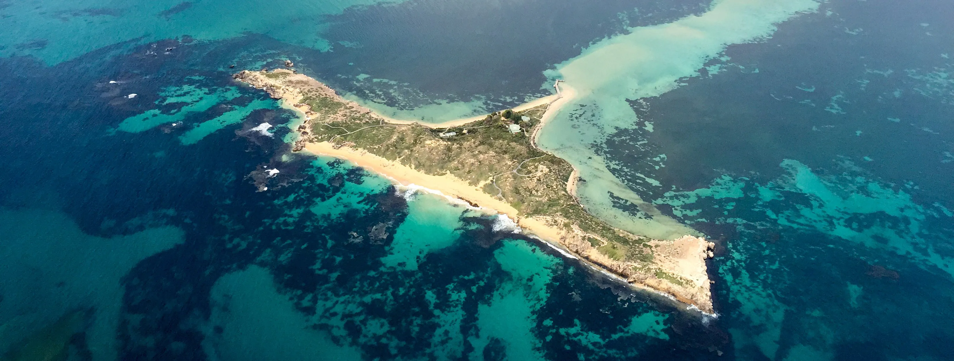 Aerial view of a small island in turquoise water off the Western Australian coast, photographed from a club aircraft