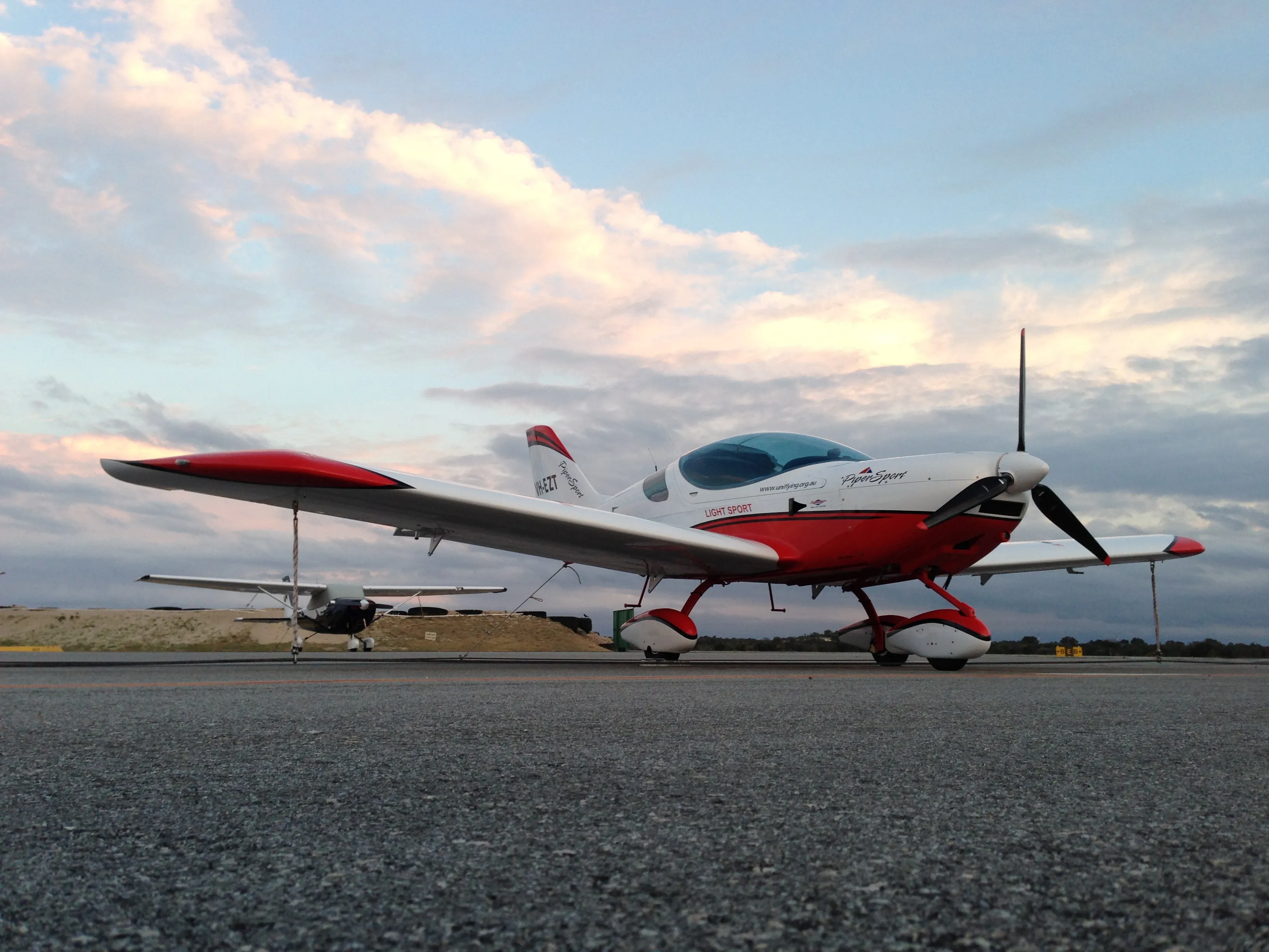VH-EZT tied down at Jandakot beneath pink evening clouds