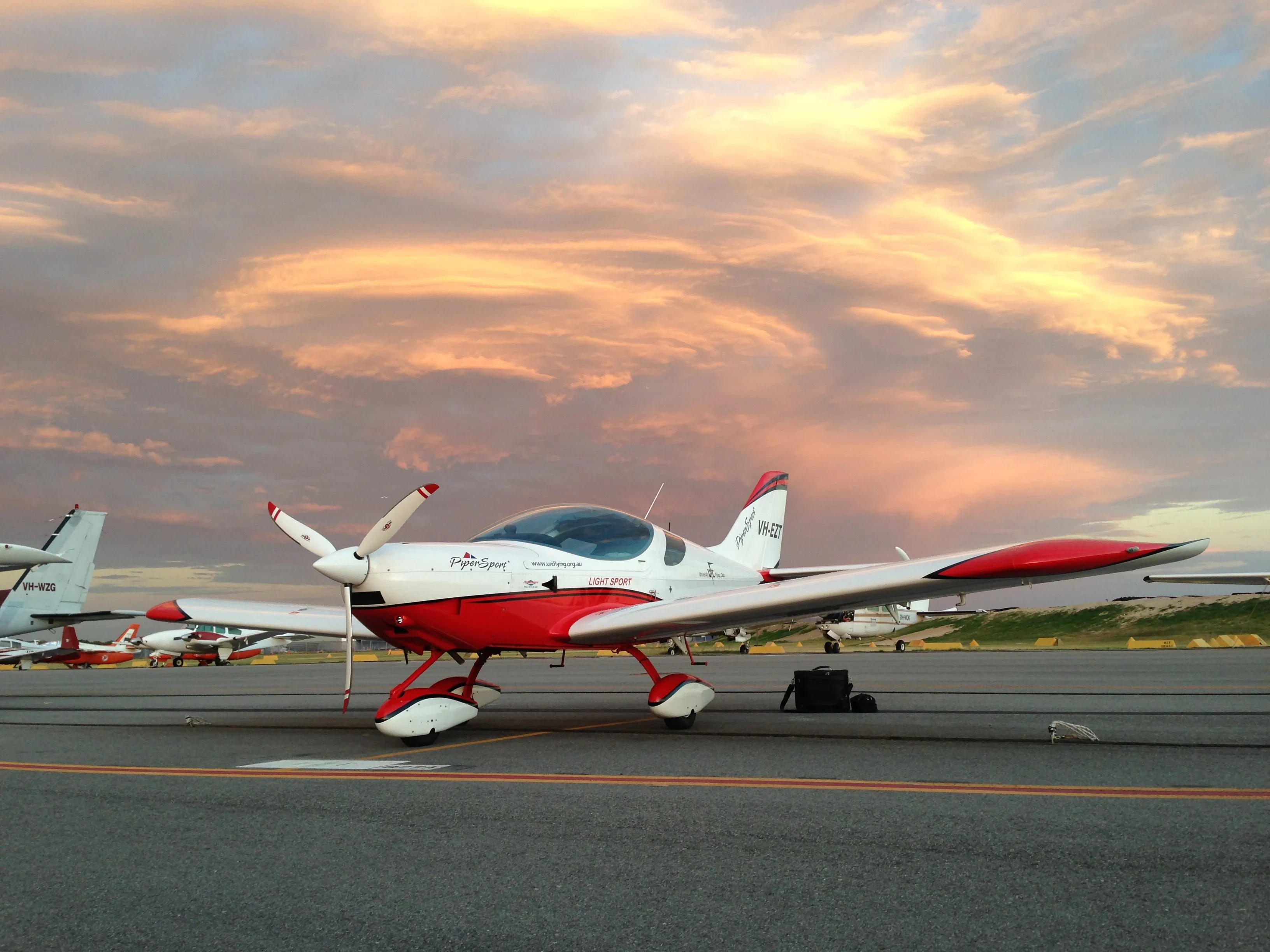 VH-EZT on the Jandakot apron under an orange sunset sky