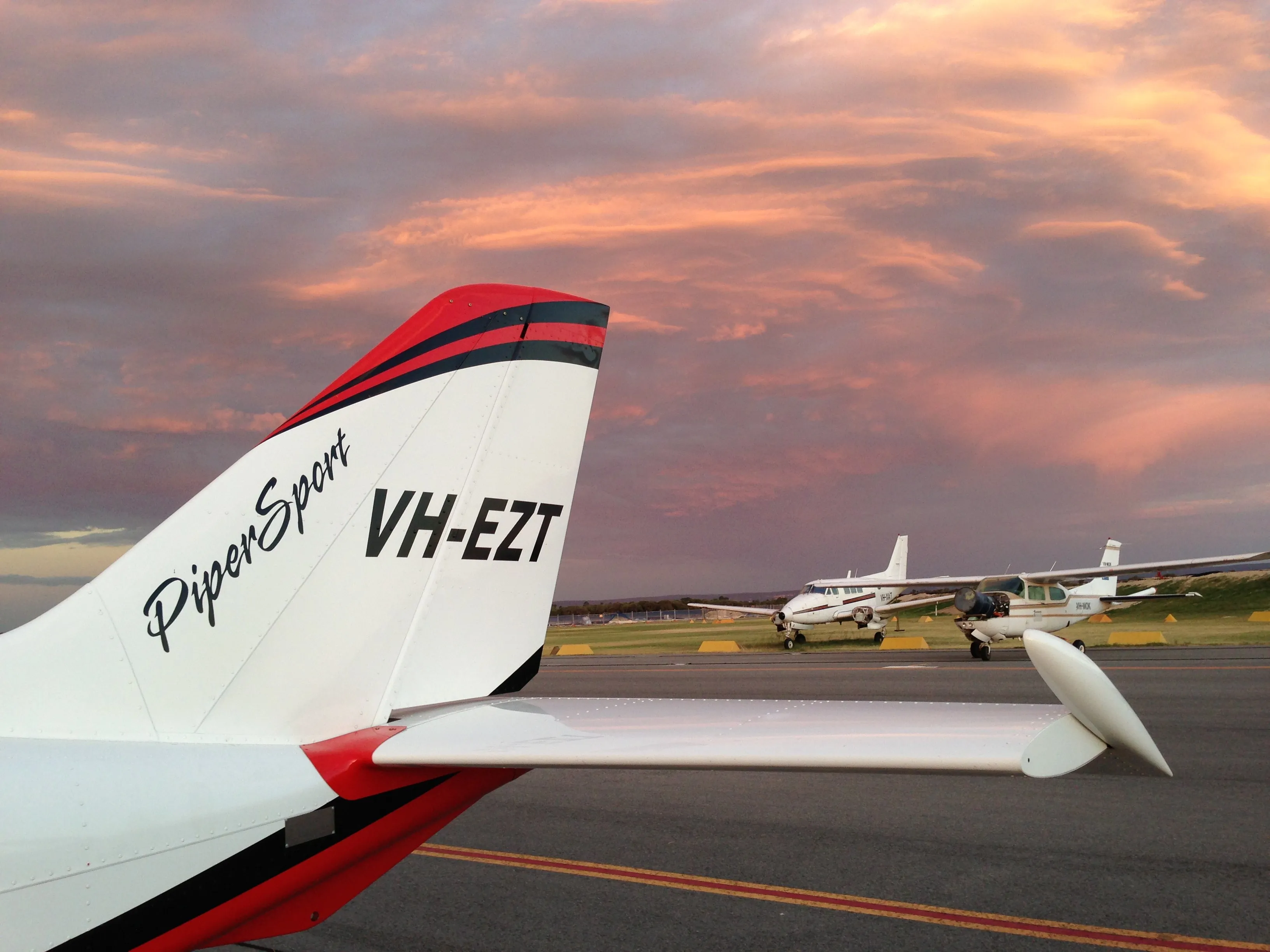 VH-EZT's tail against pink sunset clouds at Jandakot