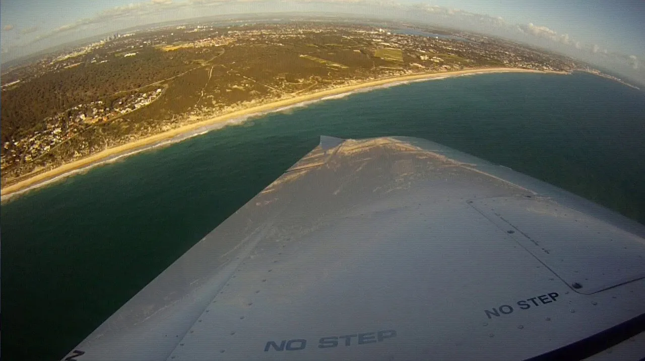 Perth's beaches seen over VH-EZT's wing during a turn
